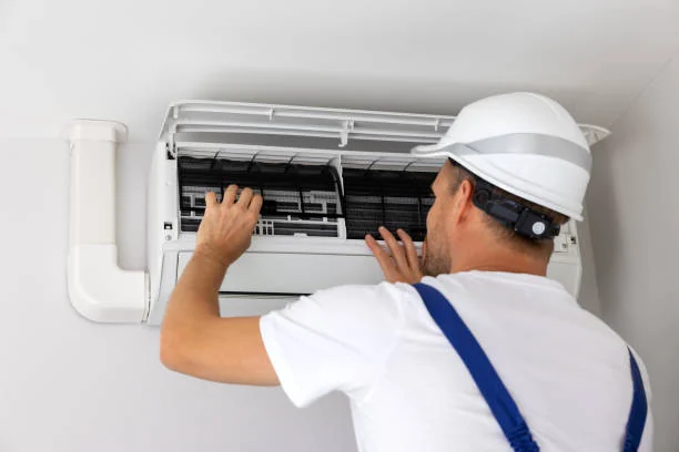 Technician inspecting an indoor HVAC filter as part of an air-quality check